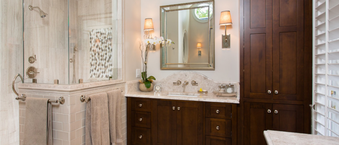 Bathroom with glass & tile shower and dark wooden cabinets